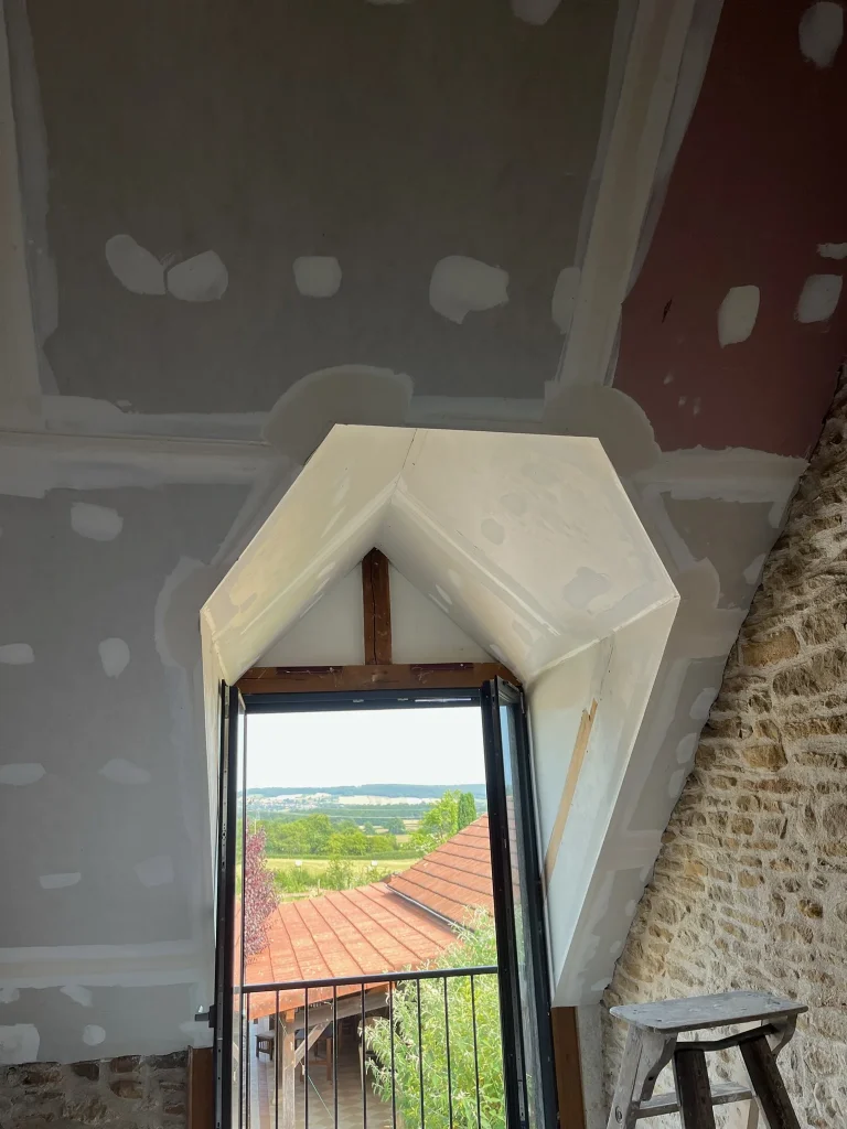 Plaques de plâtre avec joints enduits autour d'une ouverture sous un plafond en pente