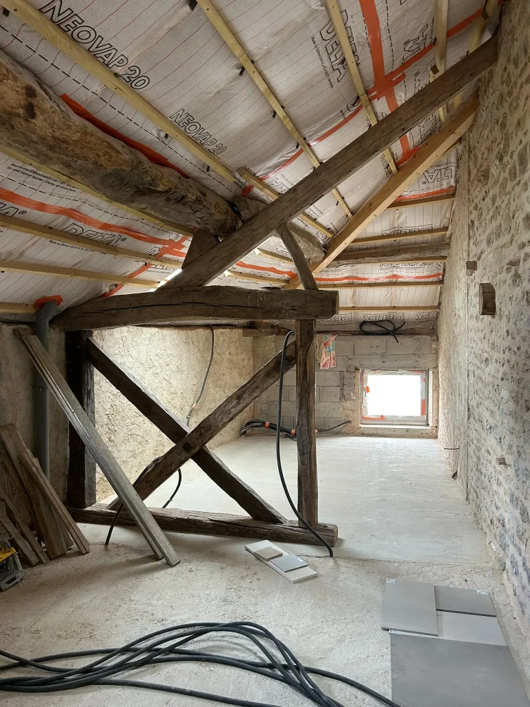 Rampants isolés avec membrane et charpente en bois apparente dans une pièce en chantier